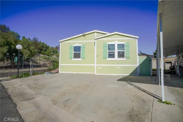 a view of a house with backyard and trees