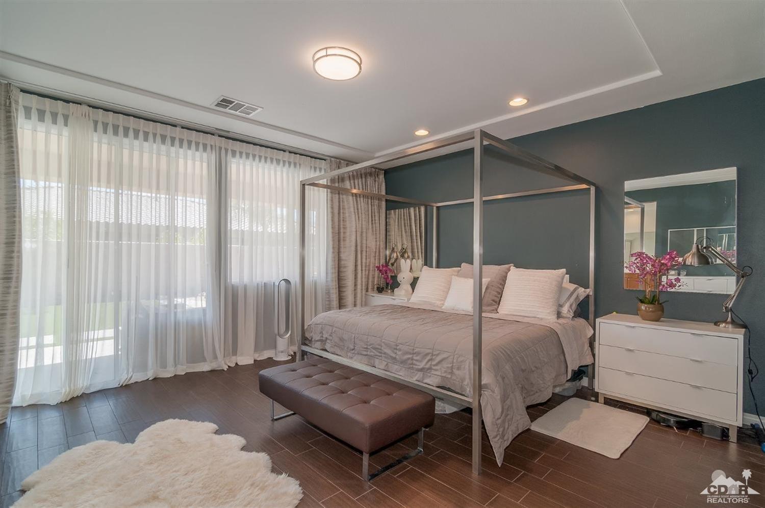 83403 Lightning Road Indio, CA 92203 - Photo 15 of 32 a bedroom with a bed mirror and couch