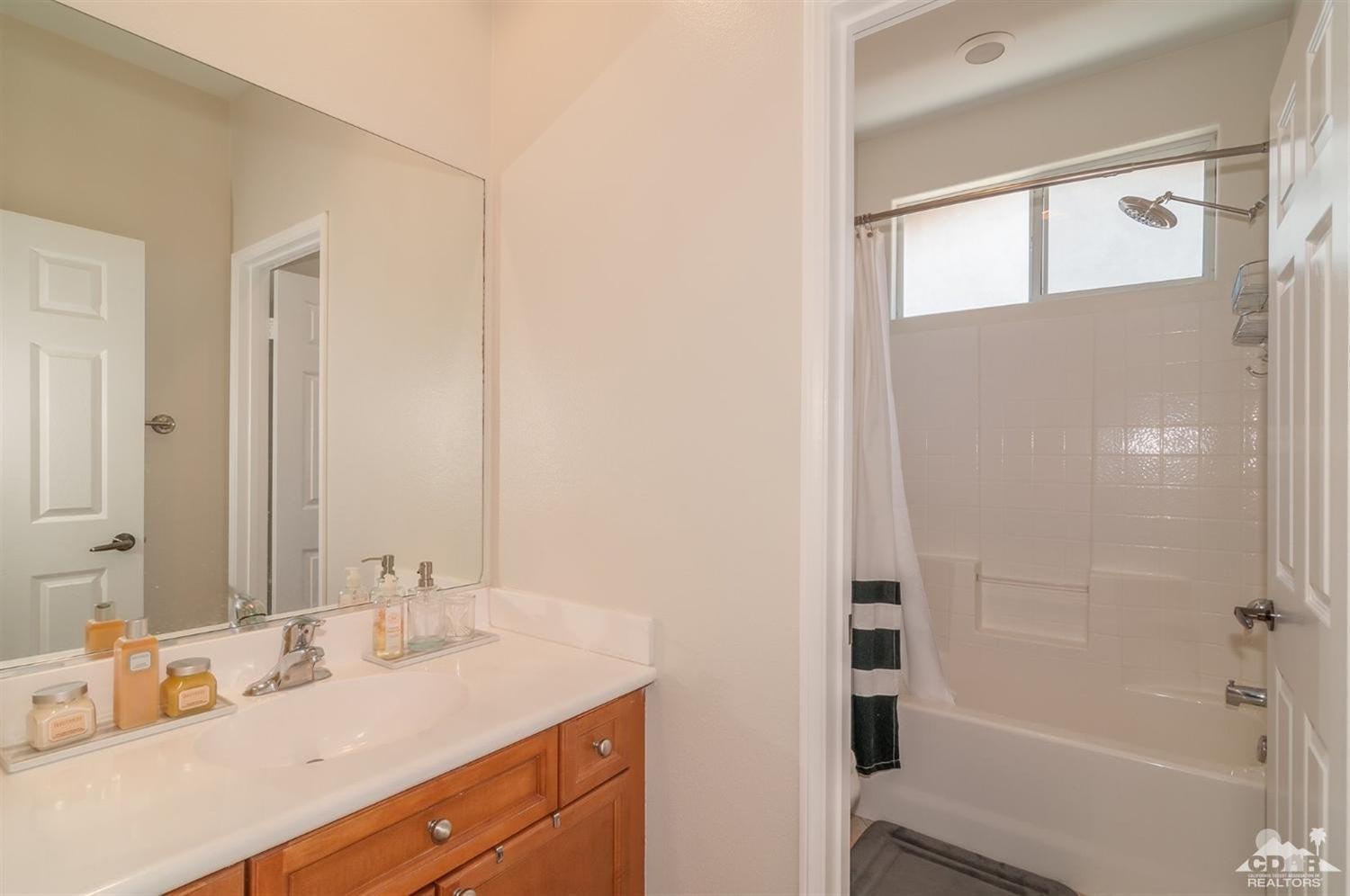 83403 Lightning Road Indio, CA 92203 - Photo 23 of 32 a bathroom with a granite countertop sink mirror and a bathtub