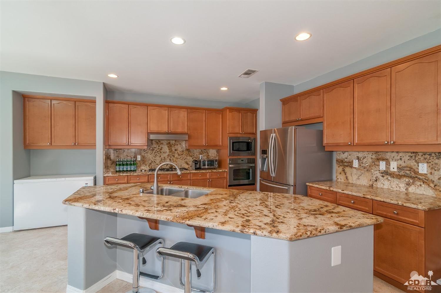 83403 Lightning Road Indio, CA 92203 - Photo 8 of 32 a kitchen with stainless steel appliances granite countertop counter space and a refrigerator