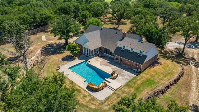 an aerial view of a house with yard swimming pool and outdoor seating