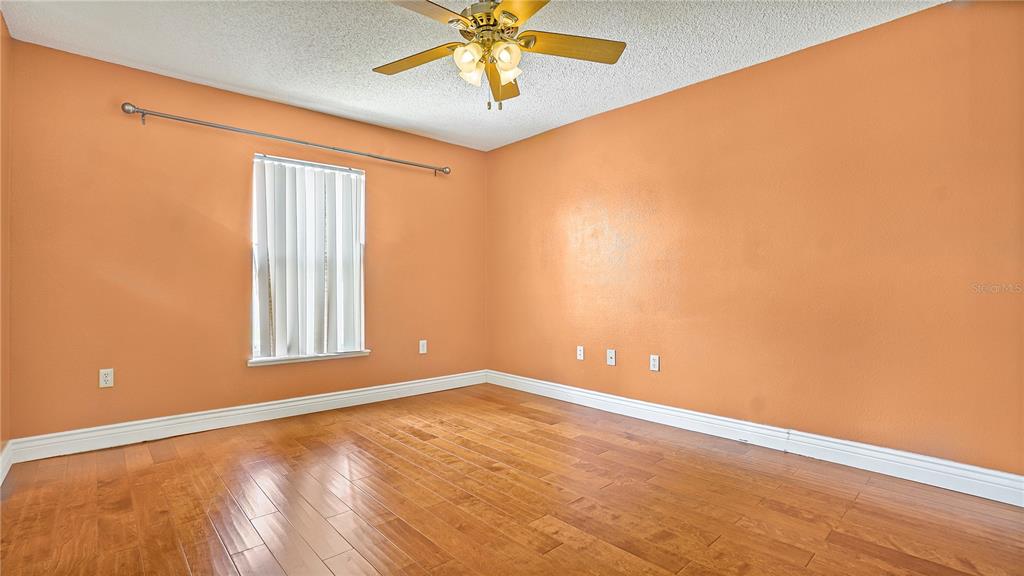 105 Caterham Way Kissimmee, FL 34758 - Photo 13 of 34 wooden floor in an empty room with a window