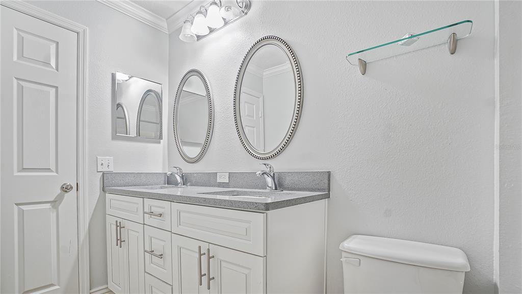 105 Caterham Way Kissimmee, FL 34758 - Photo 18 of 34 a bathroom with a granite countertop sink a toilet and a mirror