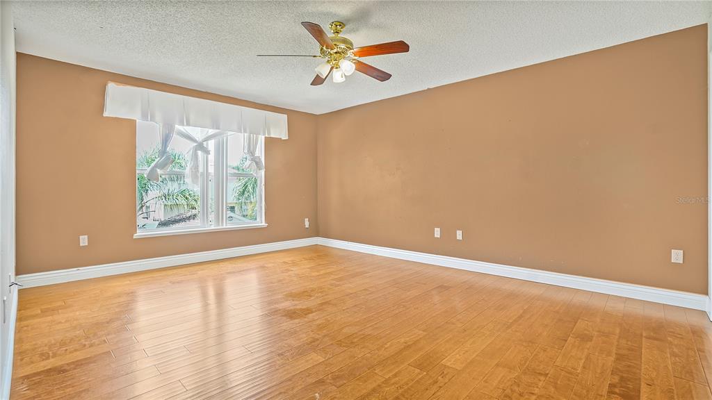 105 Caterham Way Kissimmee, FL 34758 - Photo 19 of 34 an empty room with windows and a ceiling fan