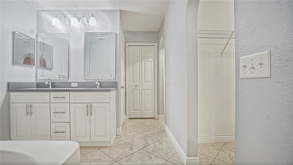 105 Caterham Way Kissimmee, FL 34758 - Photo 29 of 34 a bathroom with a sink and a mirror