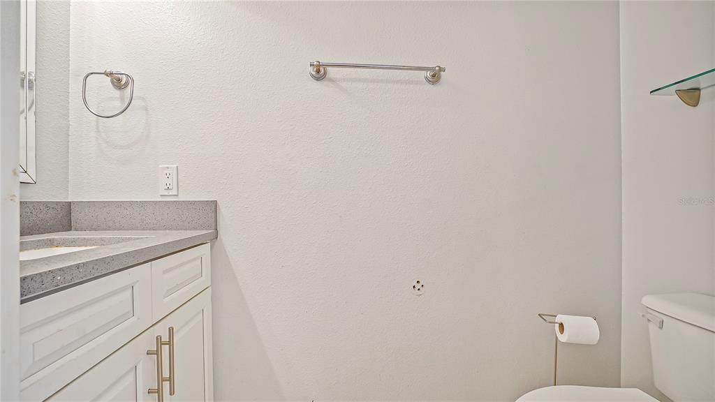 105 Caterham Way Kissimmee, FL 34758 - Photo 5 of 34 a bathroom with a granite countertop sink a toilet and a mirror