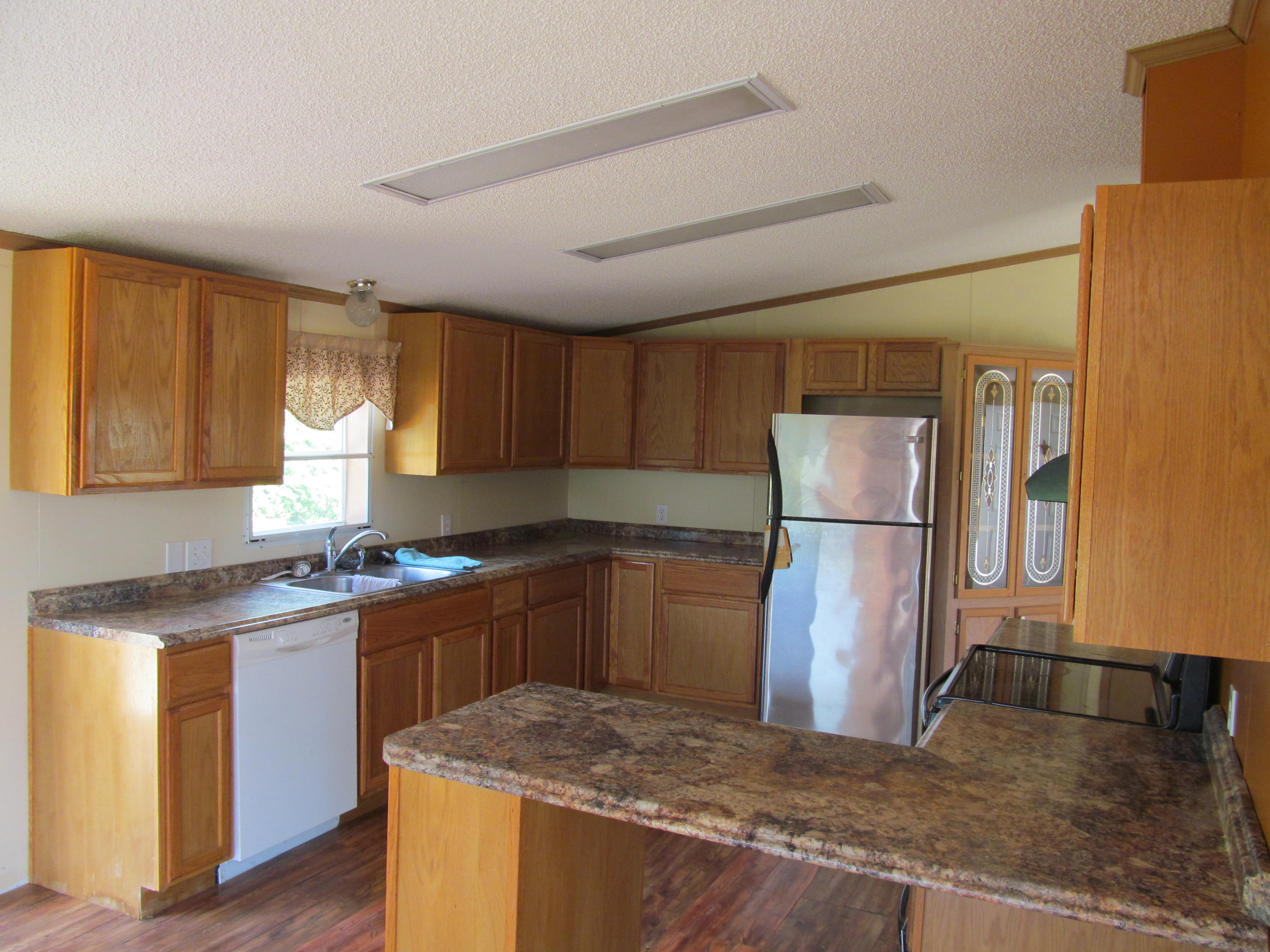 3016 Quarles Road Thaxton, VA 24174 - Photo 4 of 41 a kitchen with stainless steel appliances granite countertop a refrigerator a sink dishwasher a stove with wooden cabinets and floor