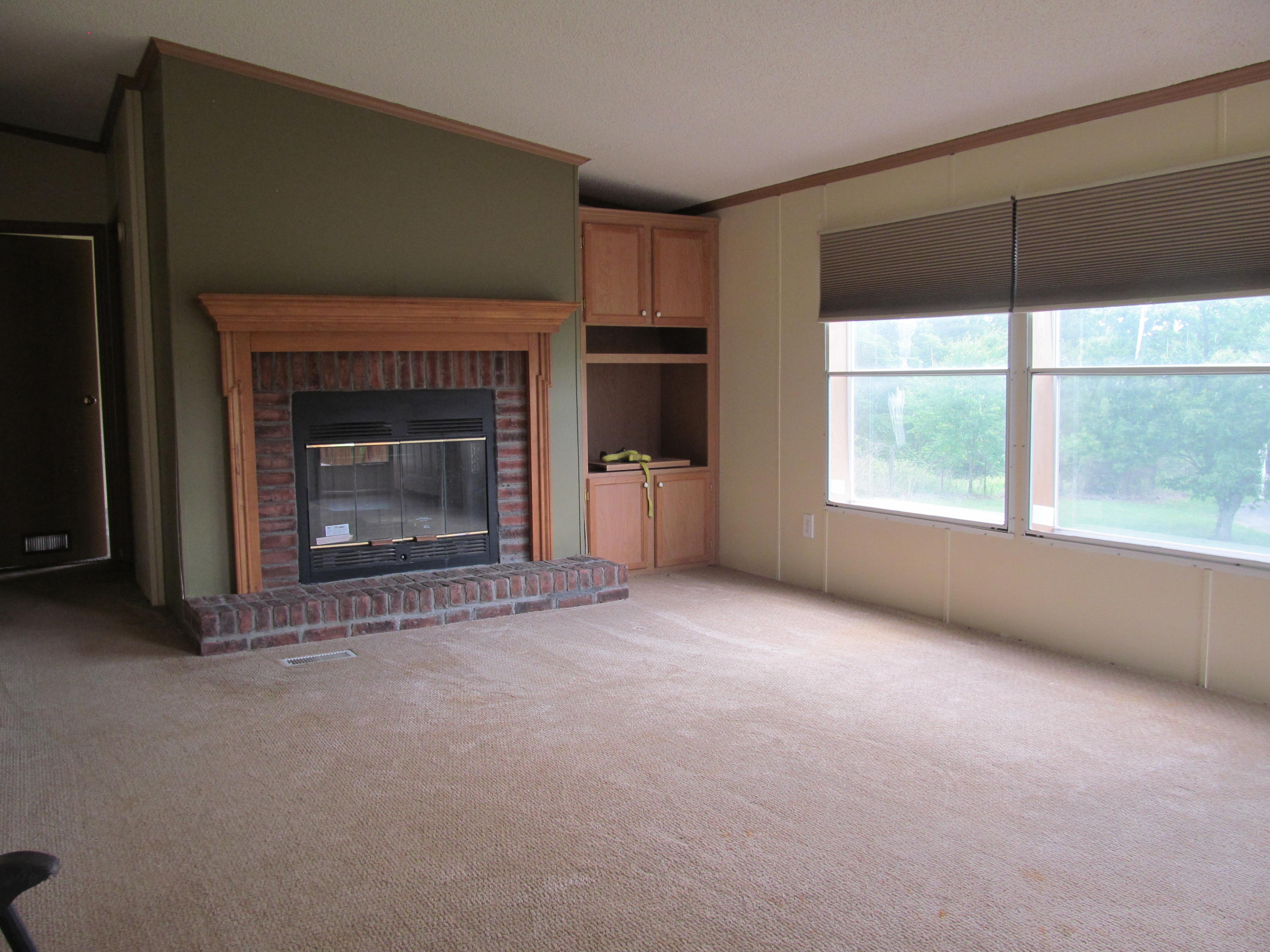 3016 Quarles Road Thaxton, VA 24174 - Photo 8 of 41 an empty room with a fireplace and window
