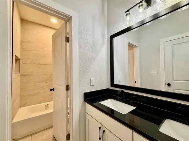 a bathroom with a granite countertop sink and a mirror