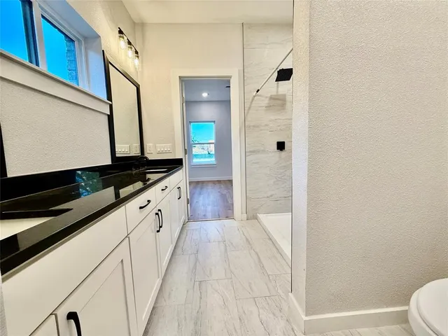 a bathroom with a granite countertop sink and a mirror