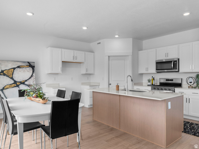 738 West 2840 South, Unit 6 Nibley, UT 84321 - Photo 12 of 23 Kitchen and dining area featuring a light wood-finish island with a white countertop and integrated sink