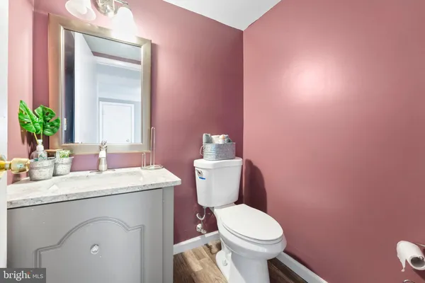 a bathroom with a sink vanity mirror and toilet