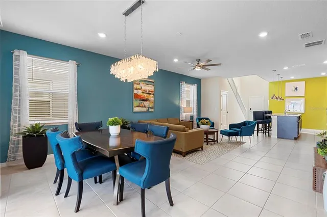 a dining room with furniture a chandelier and window
