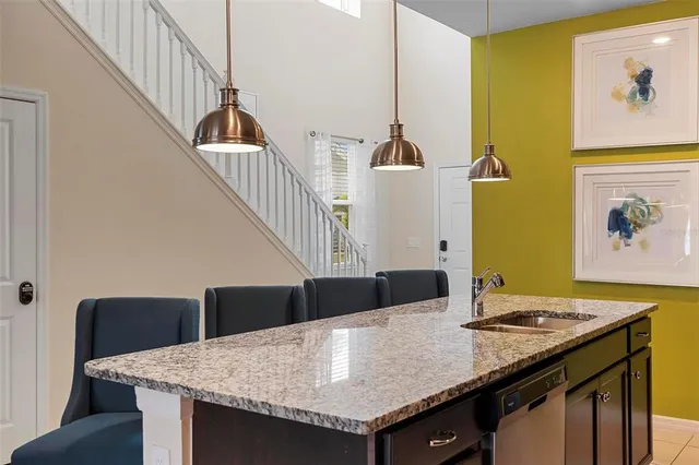 a kitchen with stainless steel appliances granite countertop a sink a stove a refrigerator a microwave oven with a dining table and chair