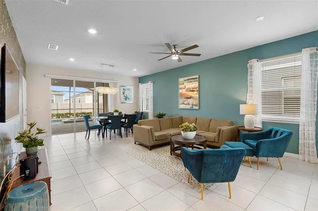 a living room with furniture flowerpot and a chandelier