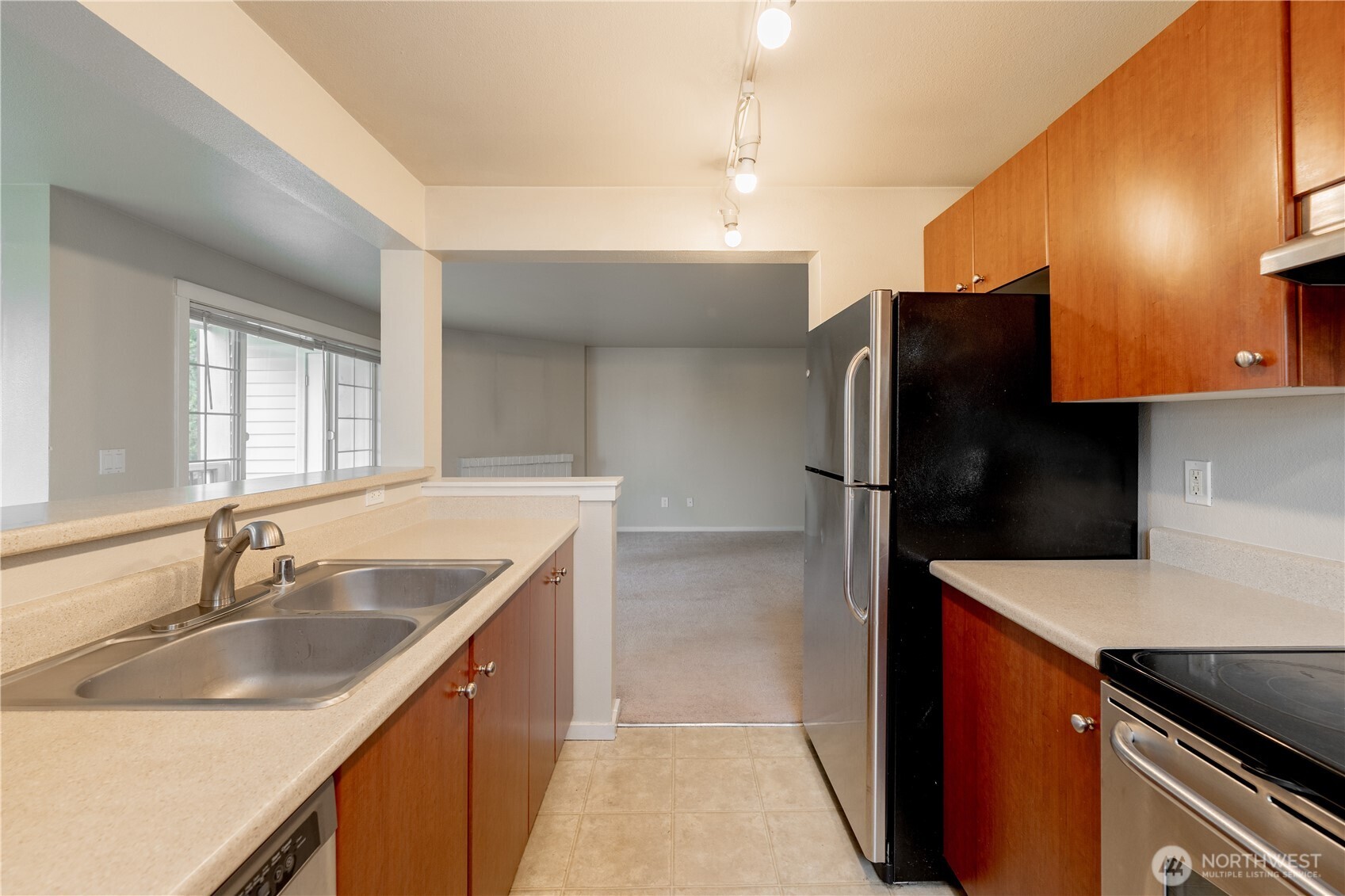 12404 East Gibson Road, Unit Q201 Everett, WA 98204 - Photo 14 of 40 a kitchen with stainless steel appliances granite countertop a sink and a refrigerator