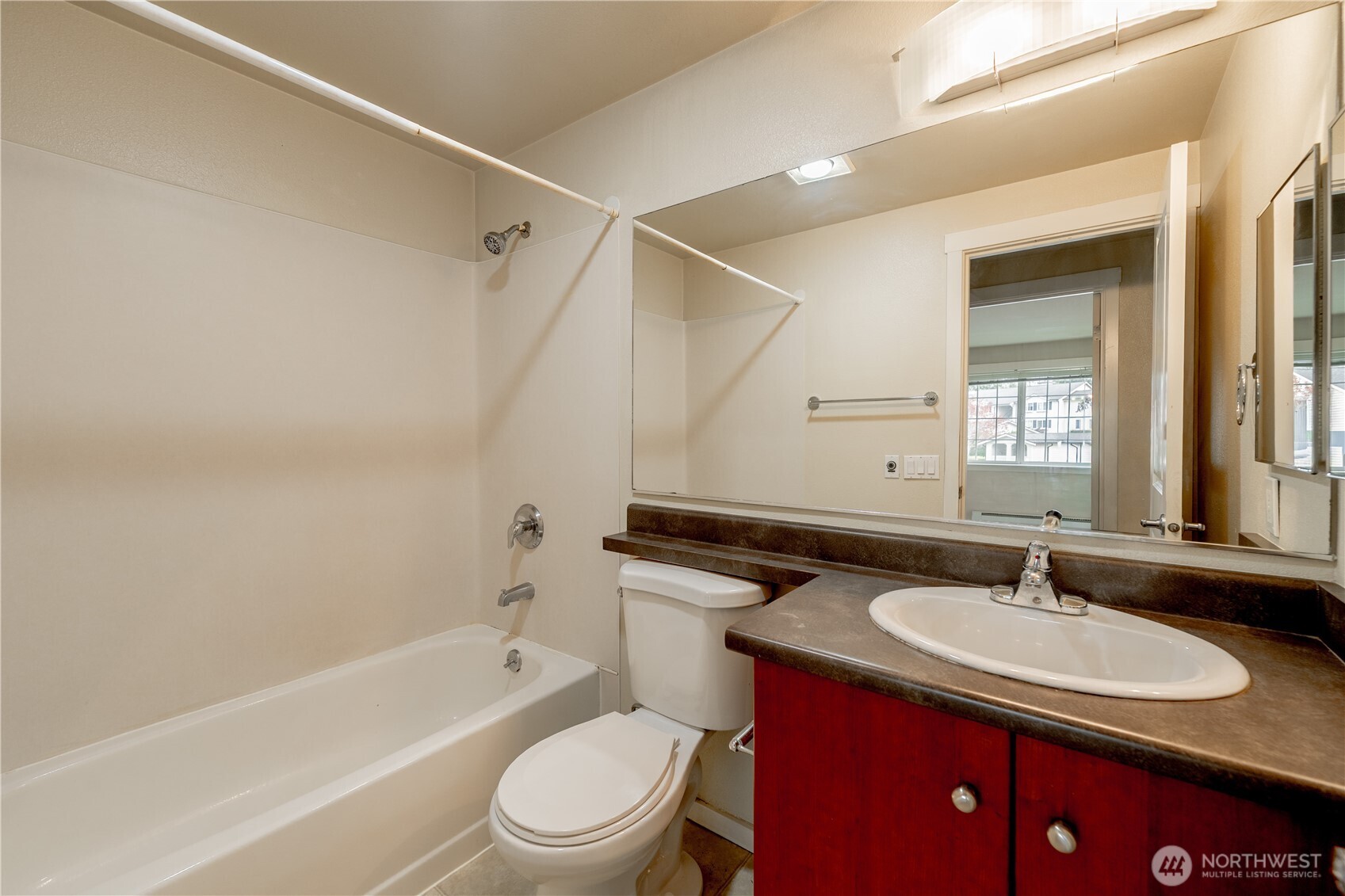 12404 East Gibson Road, Unit Q201 Everett, WA 98204 - Photo 26 of 40 a bathroom with a granite countertop sink toilet a mirror and bathtub