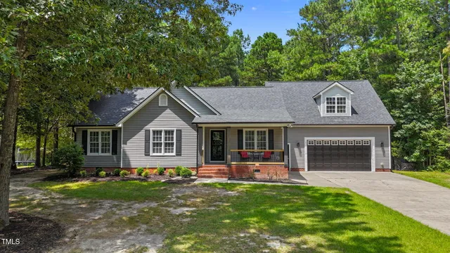 a front view of a house with a garden and yard