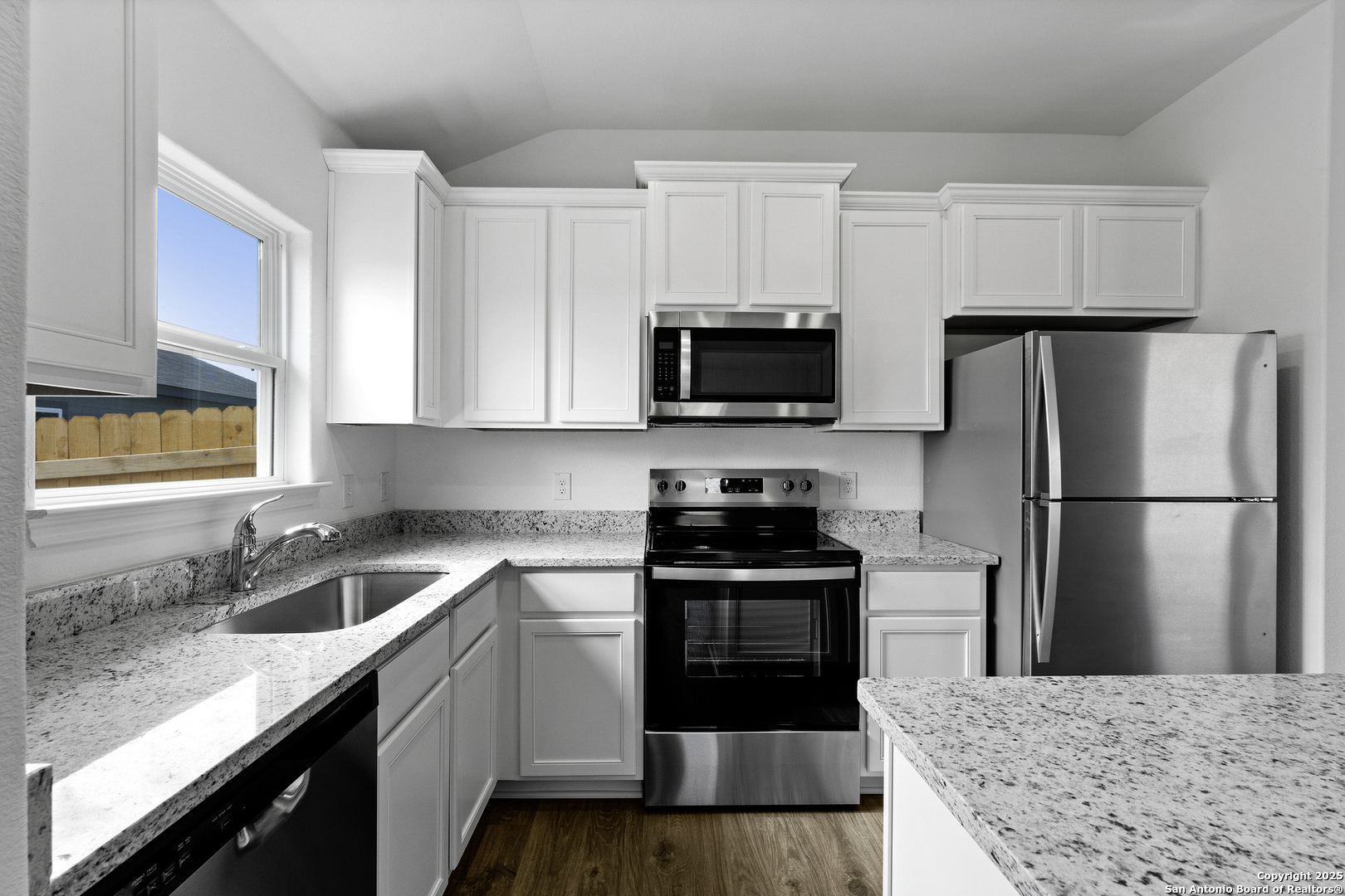 16004 Stratford Cove Lytle, TX 78052 - Photo 8 of 29 a kitchen with a sink a microwave a refrigerator and cabinets