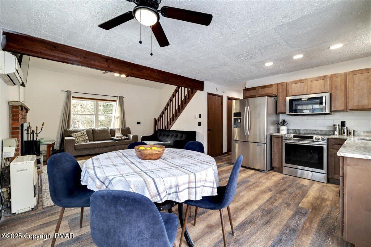 1662 Cotswald Road Tobyhanna, PA 18466 - Photo 12 of 43 a open kitchen with stainless steel appliances granite countertop a refrigerator a stove a sink a dining table and chairs with wooden floor