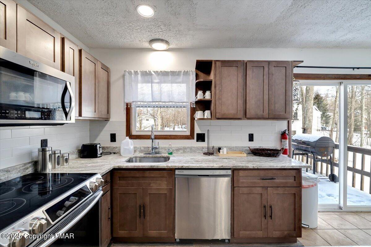 1662 Cotswald Road Tobyhanna, PA 18466 - Photo 15 of 43 a kitchen with stainless steel appliances granite countertop a sink stove cabinets and a window