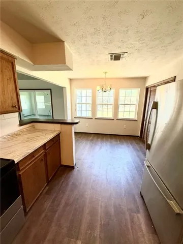 a view of a kitchen with wooden floor and electronic appliances
