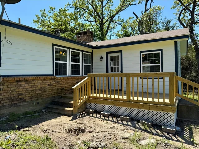 a view of a house with a wooden bench