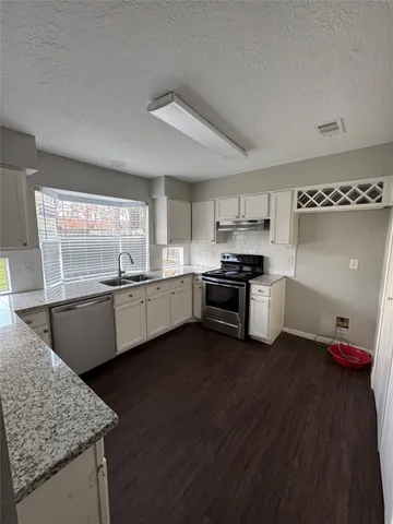 a kitchen with stainless steel appliances granite countertop a sink and a stove