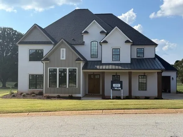 a front view of a house with a garden