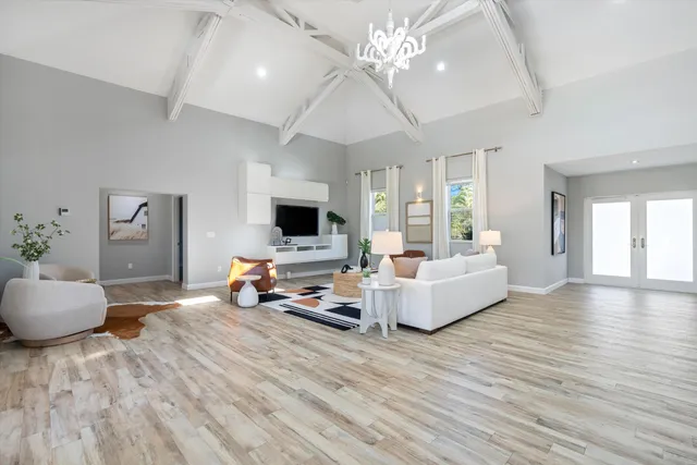 a view of an empty room with wooden floor and windows