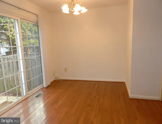 an empty room with wooden floor and windows in a room