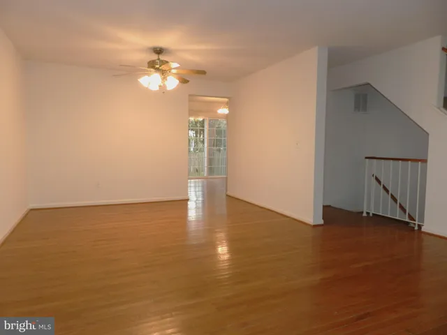 a view of a livingroom with a ceiling fan and wooden floor