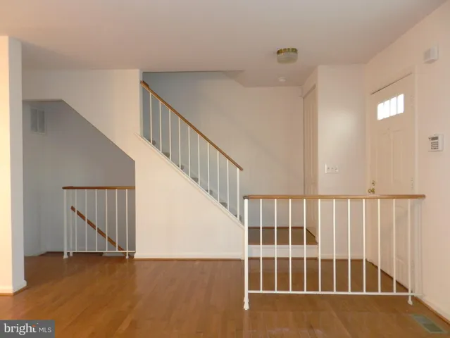 a view of staircase with white walls and wooden floor