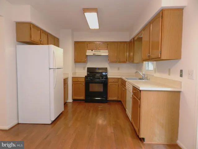 a kitchen with a white stove top oven and refrigerator
