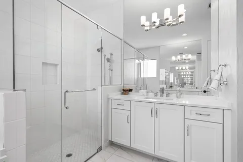 a bathroom with a double vanity sink a mirror and a shower