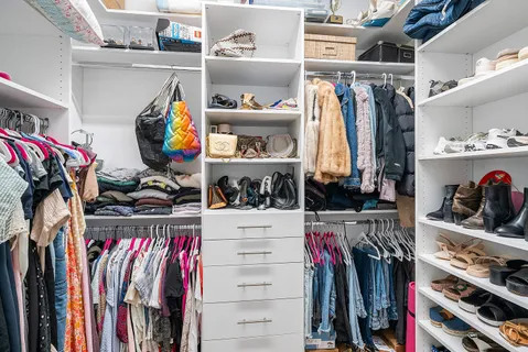 a view of walk in closet with clothes and shoes