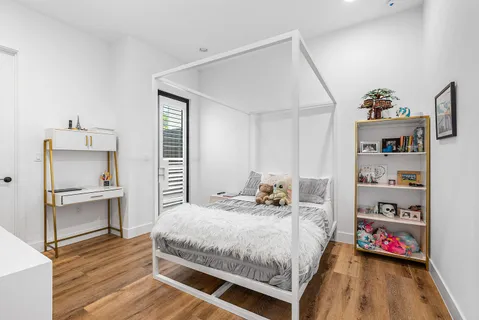 a bedroom with a bed and wooden floor