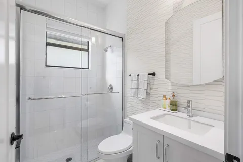 a bathroom with a sink a toilet and shower