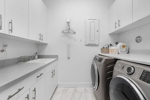a utility room with sink dryer and washer