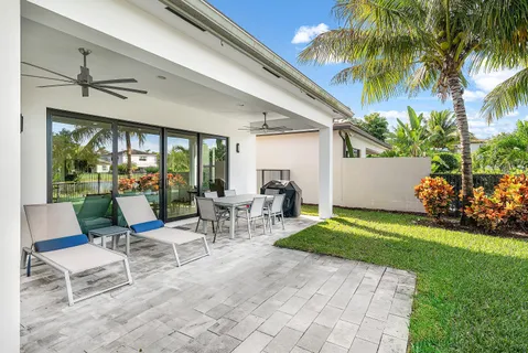a view of a patio with a dining table and chairs under an umbrella