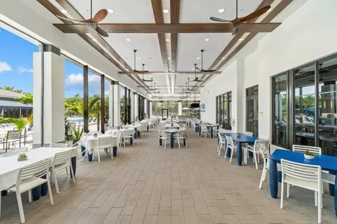 a room with lots of tables a large window and furniture