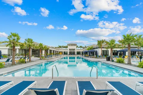 a view of a house with pool and sitting area