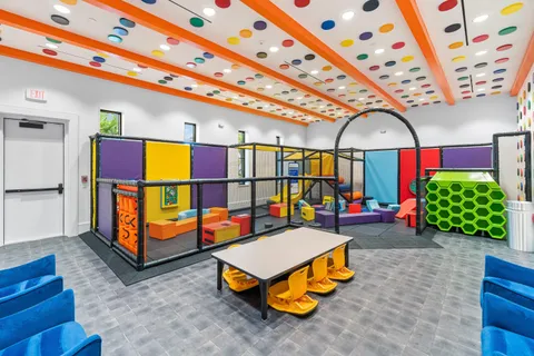 a play room with furniture and a flat screen tv