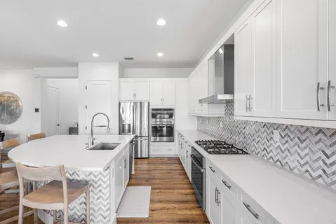 a kitchen with stainless steel appliances granite countertop a sink stove and refrigerator