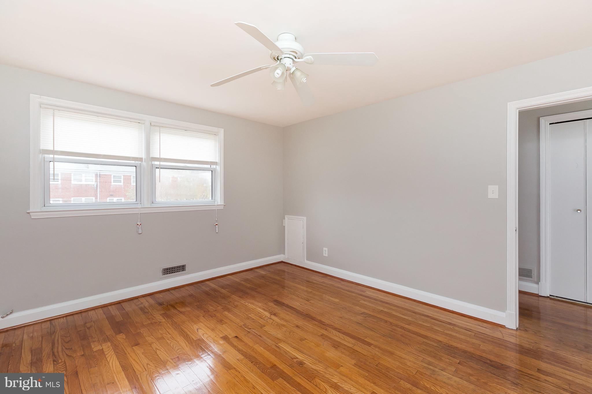 1504 Clairidge Road Baltimore, MD 21207 - Photo 17 of 30 an empty room with wooden floor fan and windows
