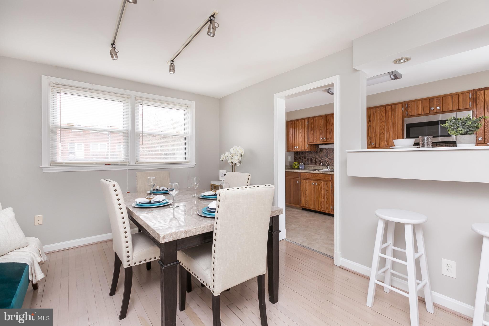 1504 Clairidge Road Baltimore, MD 21207 - Photo 9 of 30 a kitchen with a dining table chairs and refrigerator