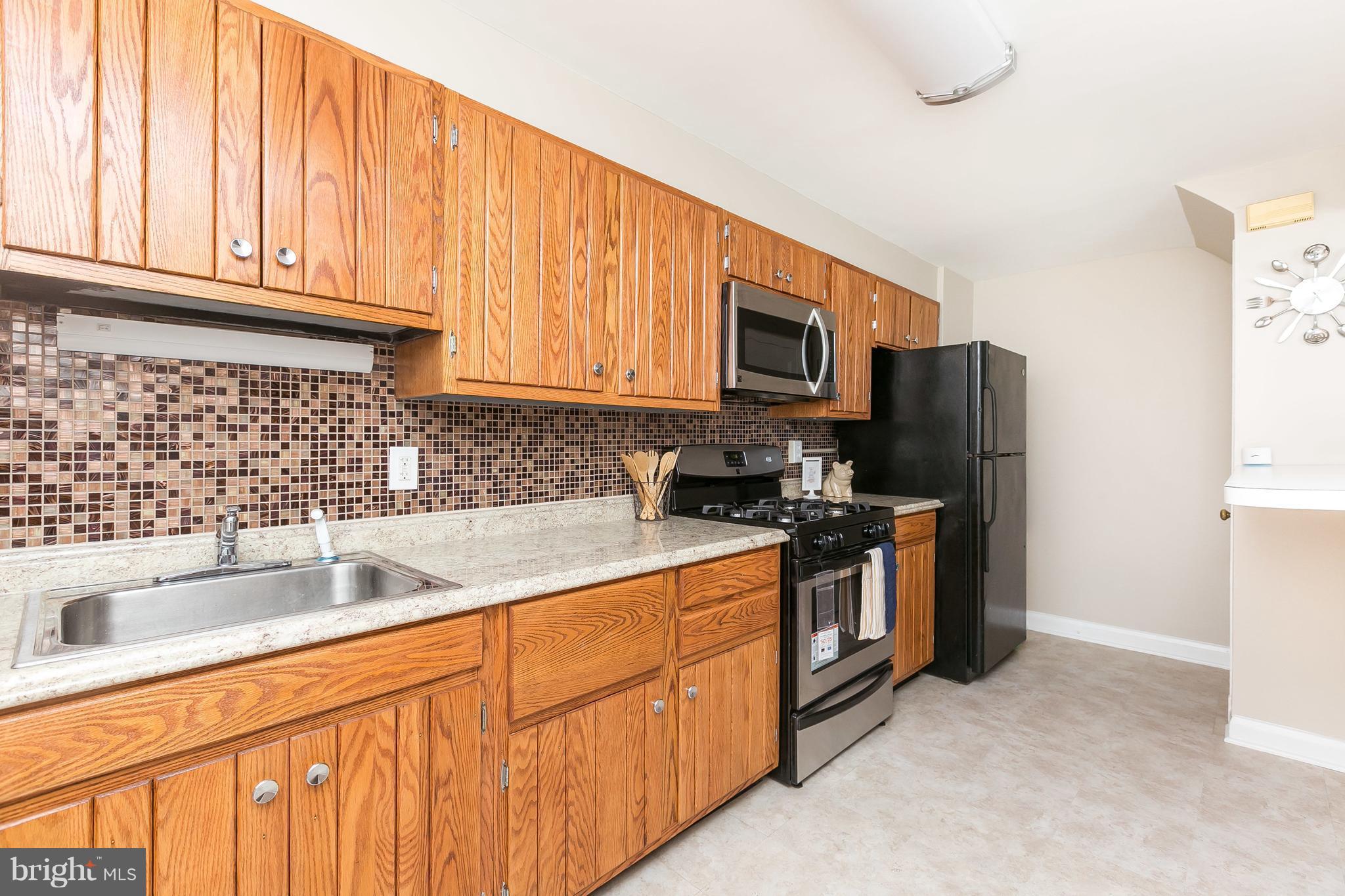 1504 Clairidge Road Baltimore, MD 21207 - Photo 10 of 30 a kitchen with stainless steel appliances granite countertop a refrigerator sink and stove