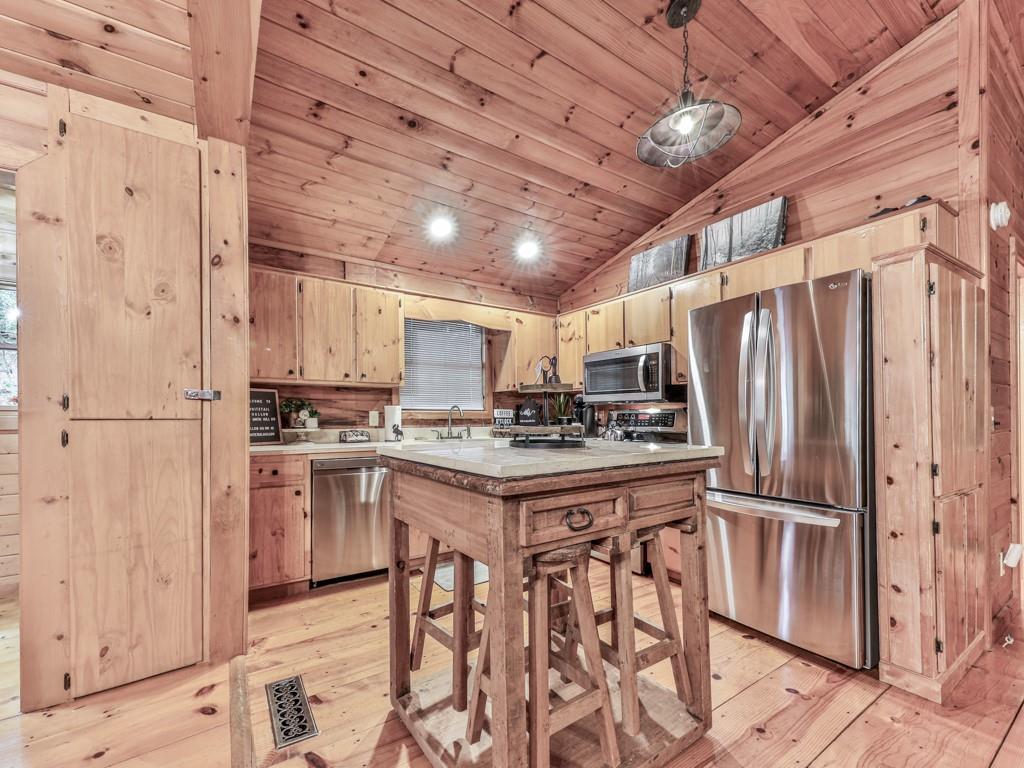 189 Smith Hill Road Blue Ridge, GA 30513 - Photo 9 of 29 a kitchen with granite countertop a refrigerator and a stove top oven