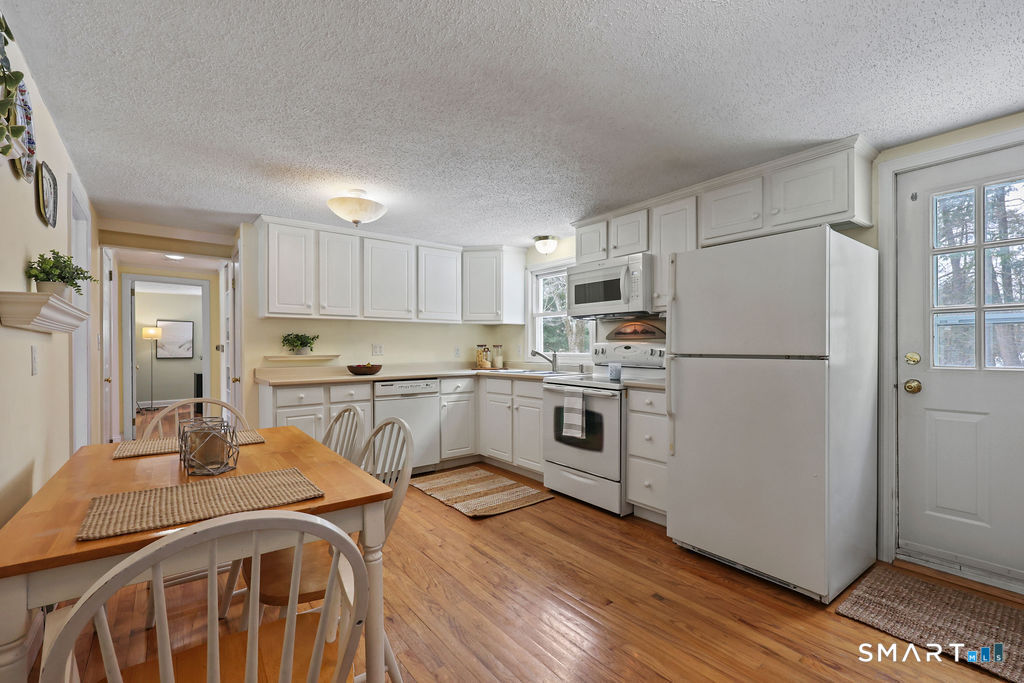 9 Barry Lane Simsbury, CT 06070 - Photo 5 of 28 a kitchen with white cabinets and white appliances