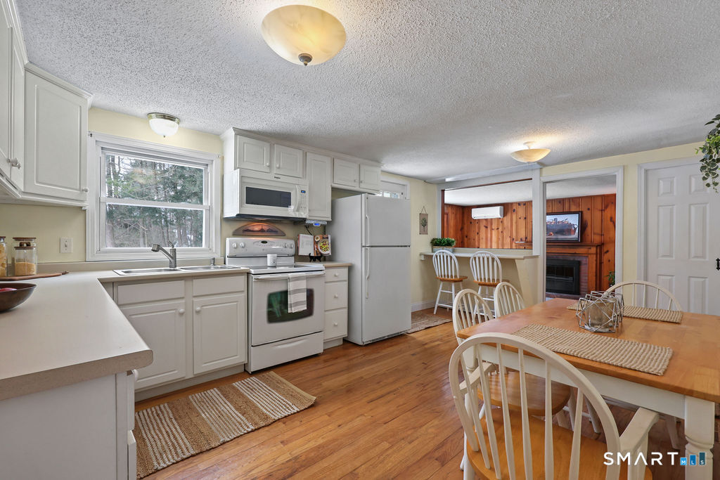 9 Barry Lane Simsbury, CT 06070 - Photo 7 of 28 a kitchen with a table chairs a oven a counter space and cabinets